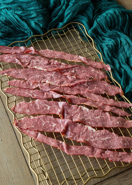 Sliced Halal Bacon on a Golden Rack surrounded by green velvet blanket