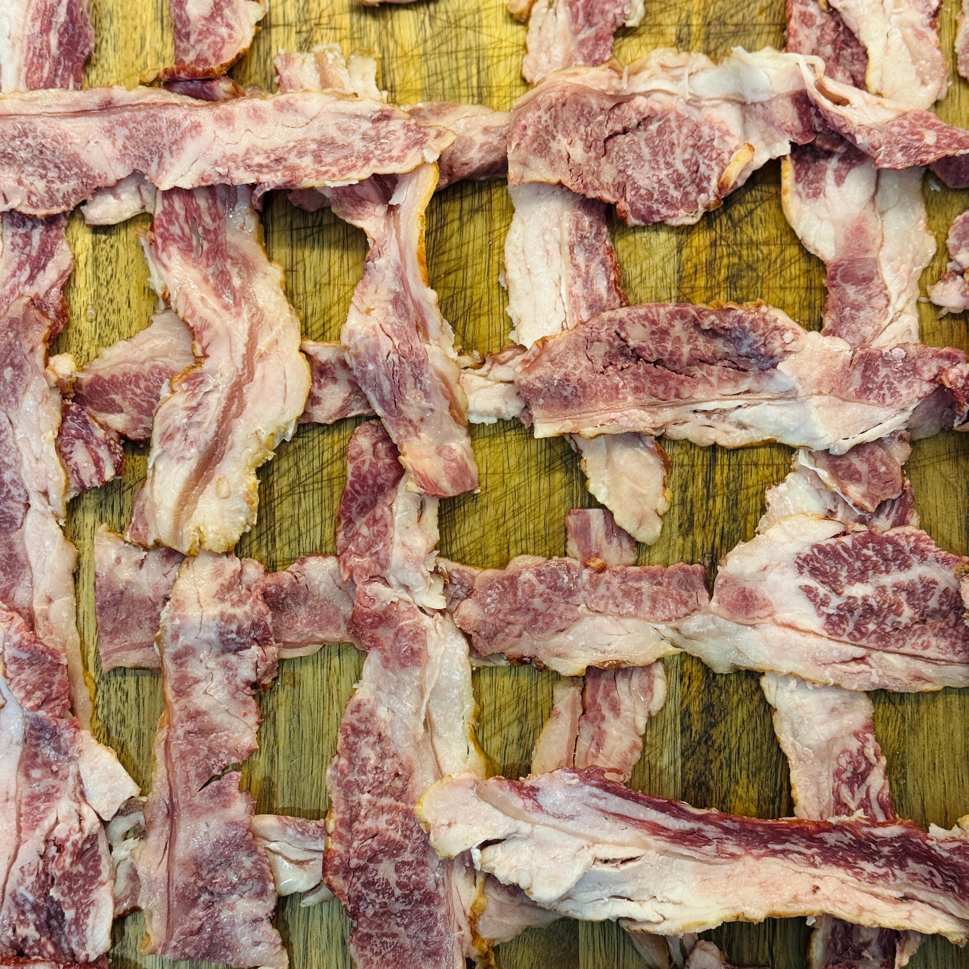 Stips of Halal Wagyu Bacon in a cross patern raw.